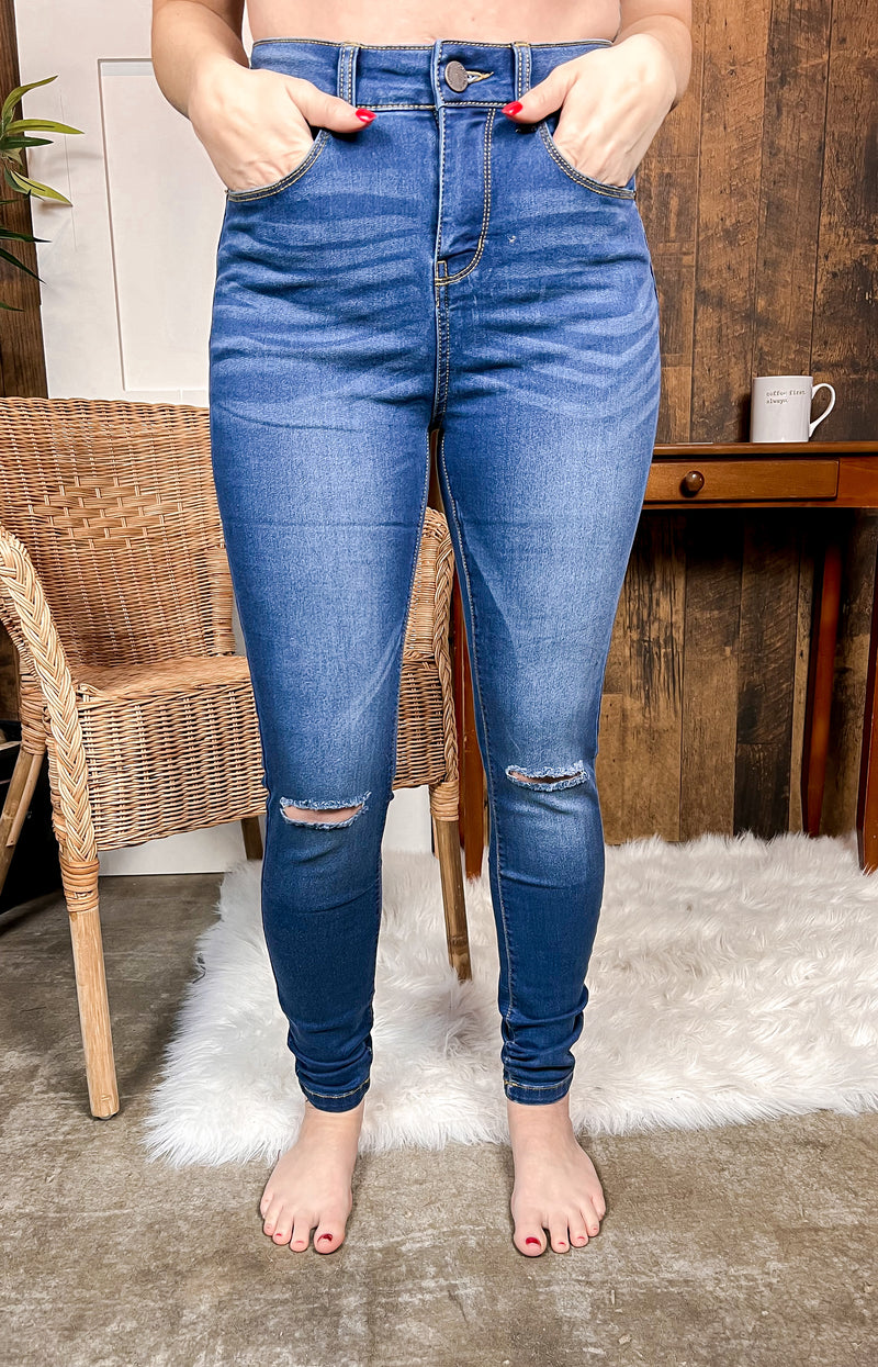 Dark wash skinny stretch denim with rips at the knee