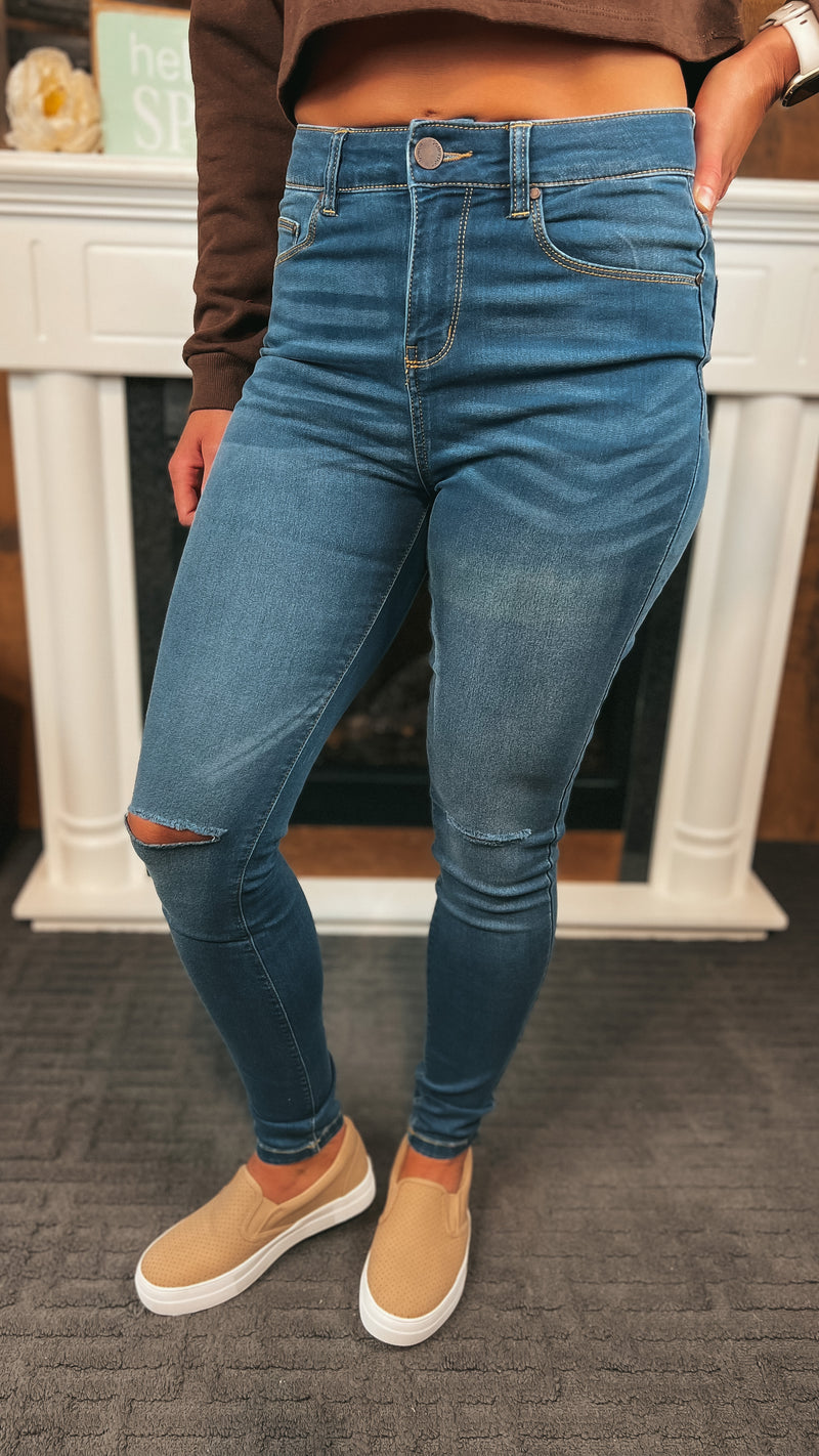Dark wash skinny stretch denim with rips at the knee